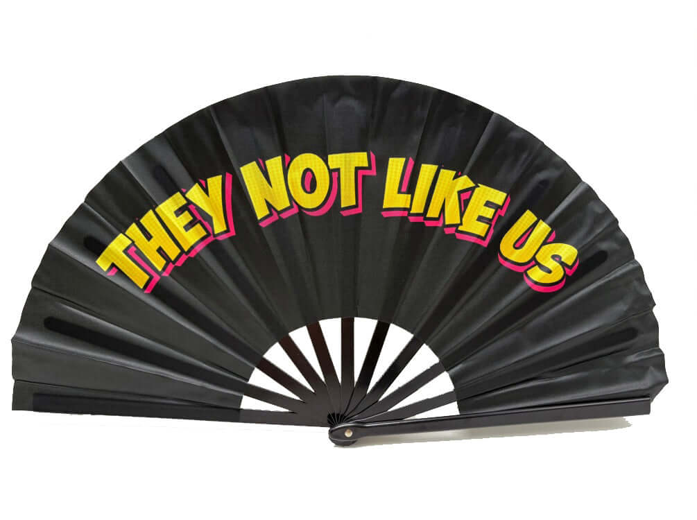 Colorful folding fan with 'THEY NOT LIKE US' text, great for events and props, 13 inches tall.