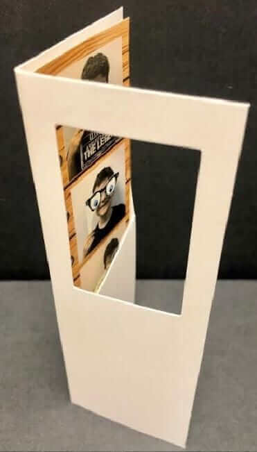 2" x 6" white photo booth strip folder with window showcasing fun photographs, ideal for events and memories.