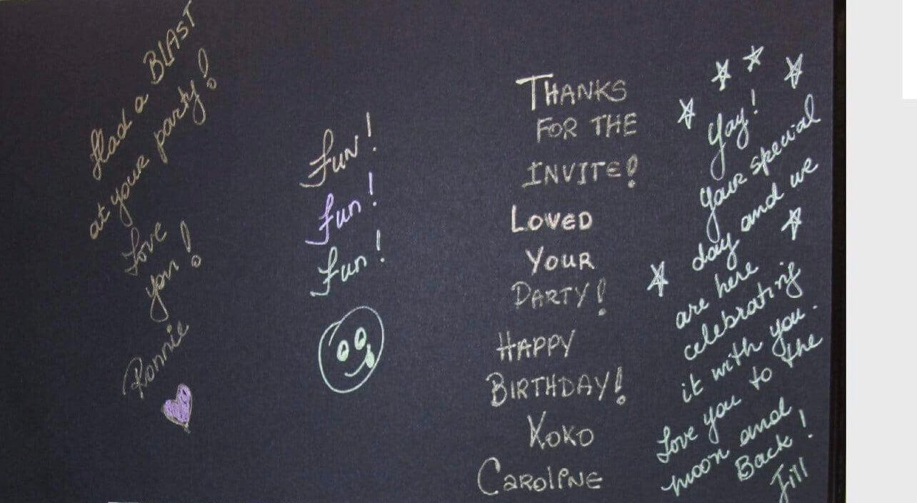 Messages and doodles on a black photo booth album page, celebrating a birthday party with fun notes.