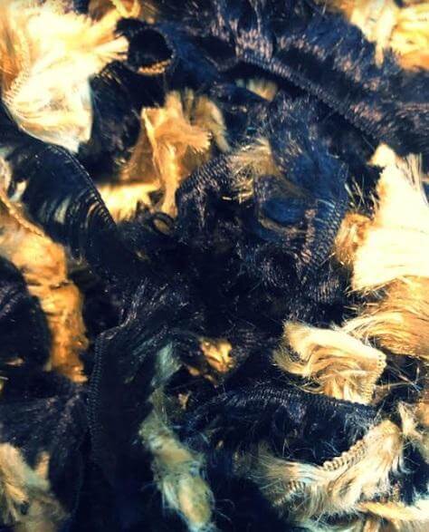Close-up of a luxurious gold and black featherless boa, showcasing its soft texture and vibrant colors.