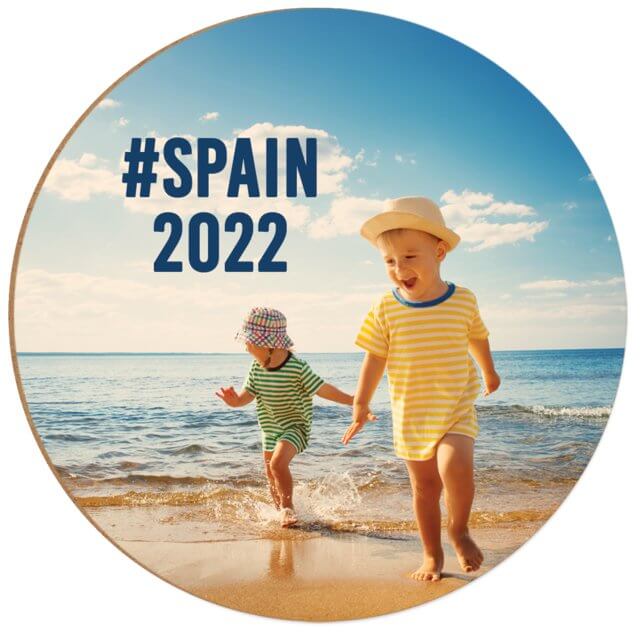 Two children playing on the beach with #SPAIN 2022 text on a round coaster design.